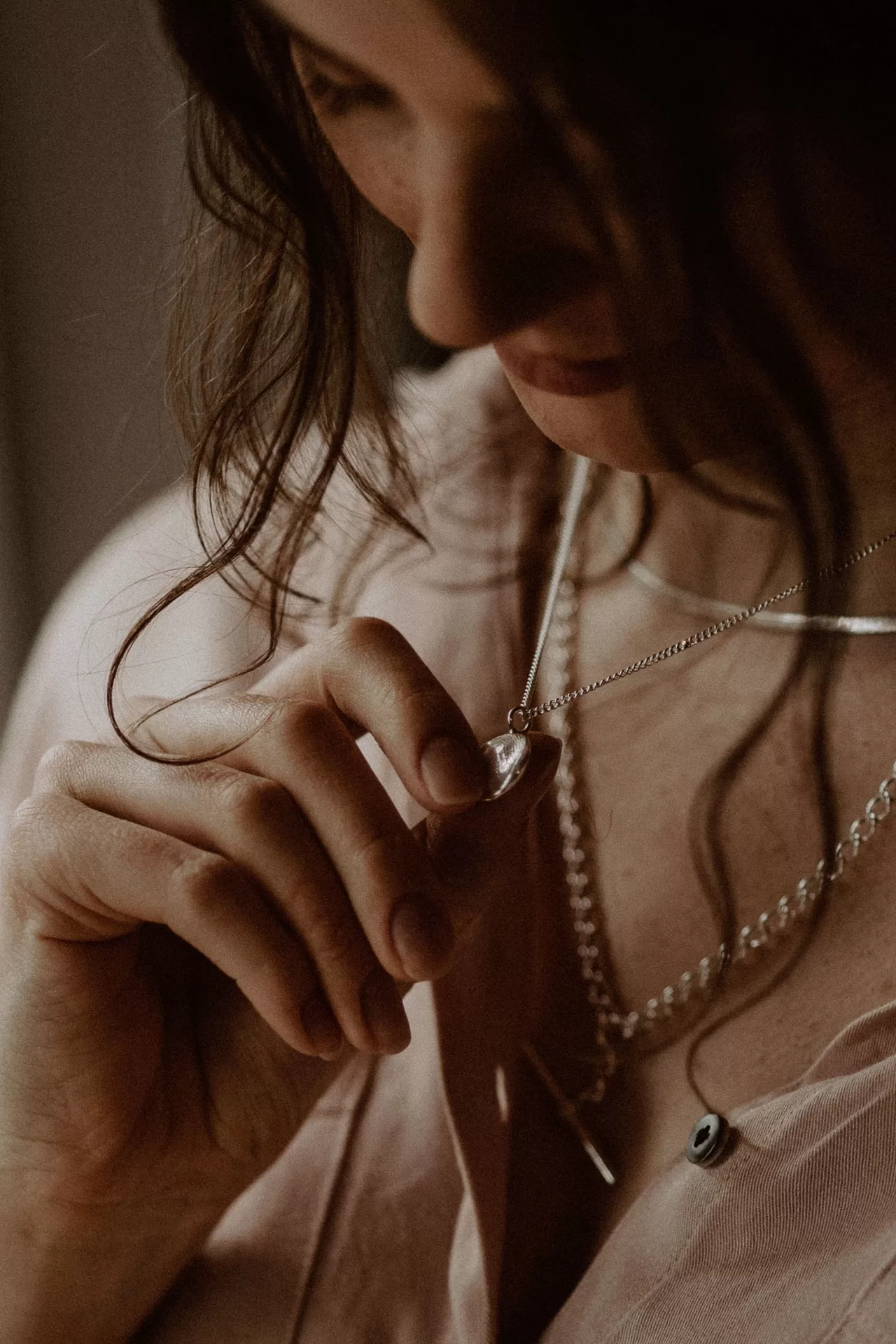 Woman holding fingerprint impression necklace from coveted in her hand