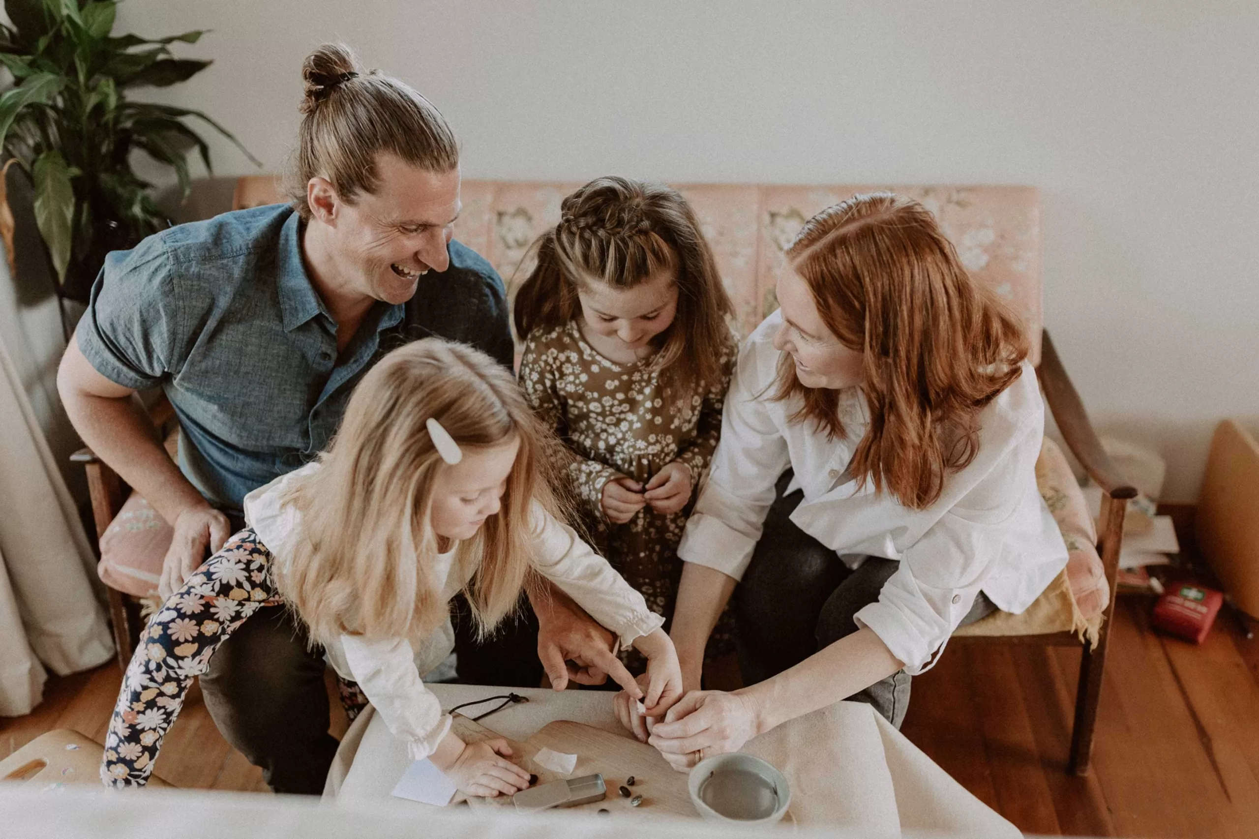 Family creating an impression necklace together with their fingerprints